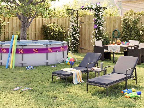 Sonniger Garten hinter dem Haus mit Aufstellpool, Poolnudeln, Schwimmbrille, Wasserball und Flip-Flops im Gras. Zwei schwarze Metall-Sonnenliegen mit grauen Auflagen stehen neben einem kleinen Beistelltisch, w&auml;hrend eine Outdoor-Essgruppe mit dunklen Geflechtsesseln bei einer bl&uuml;henden Pergola, einem Holzzaun und sommerlichen Gartenaccessoires platziert ist.
