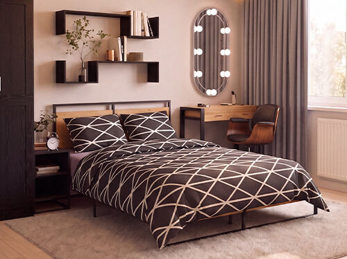 Modernes Schlafzimmer mit einem Bett aus schwarzem Metall und Holz, bezogen mit schwarz-weisser Bettw&auml;sche im geometrischen Muster, flankiert von einem passenden Nachttisch mit einem Vintage-Wecker. Ein hoher Kleiderschrank in dunkler Holzoptik steht neben schwebenden schwarzen Wandregalen, die mit B&uuml;chern, Pflanzen und dekorativen Accessoires gestaltet sind. Gegen&uuml;ber dem Bett befindet sich ein minimalistischer Schminktisch aus Holz mit schwarzem Gestell, kombiniert mit einem geschwungenen Walnussstuhl und einem ovalen Spiegel mit integrierter Beleuchtung. Bodentiefe graue Vorh&auml;nge umrahmen ein grosses Fenster, das den Raum mit warmem Tageslicht erf&uuml;llt, w&auml;hrend ein weicher cremefarbener Teppich und ein heller Holzboden f&uuml;r eine gem&uuml;tliche, moderne Atmosph&auml;re sorgen.